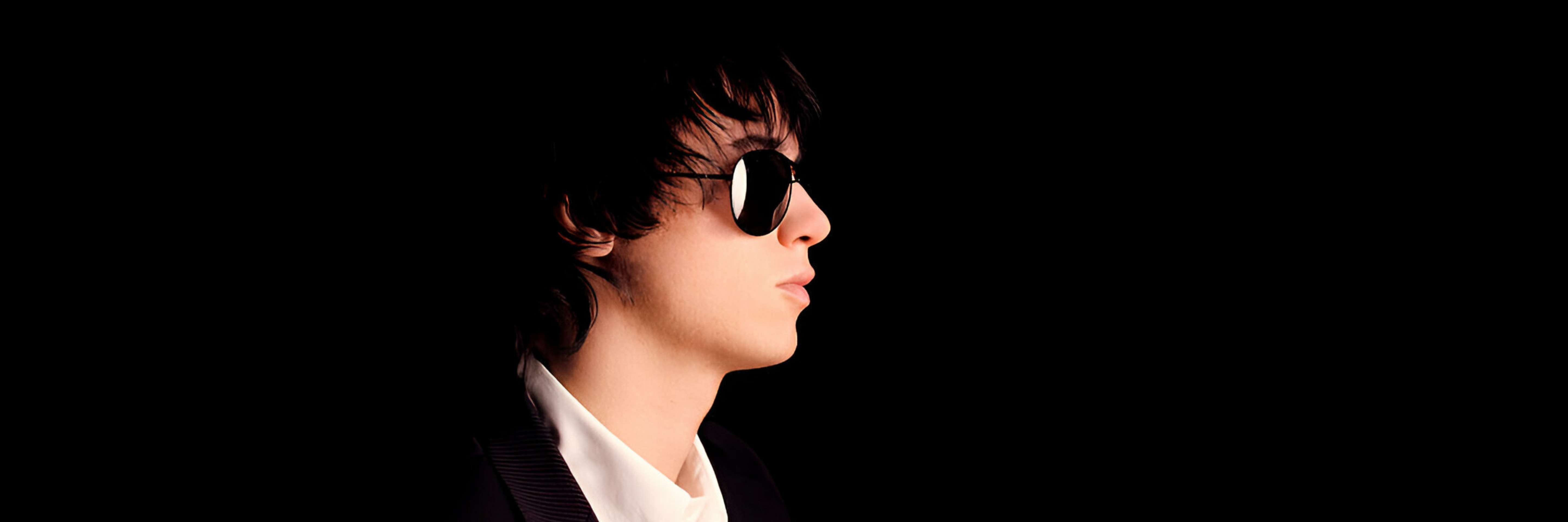 Male mode side face wearing Aviator black on black sunglasses for men and women from Missandtrendy in a black background image for desktop